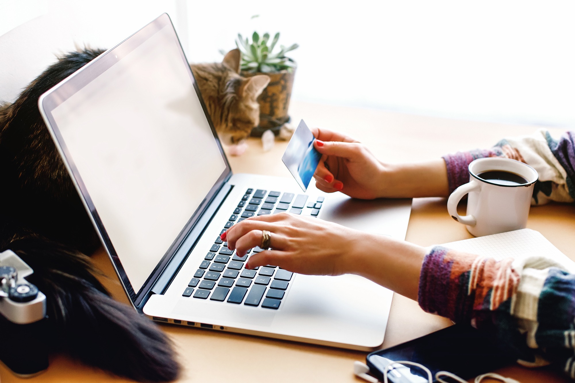 Girl holding credit card and typing on laptop